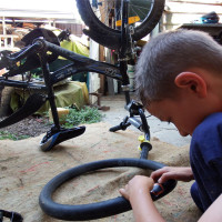 Get back on your bike Kai changing his bike tyre after a run in with <i>bindies</i>.
